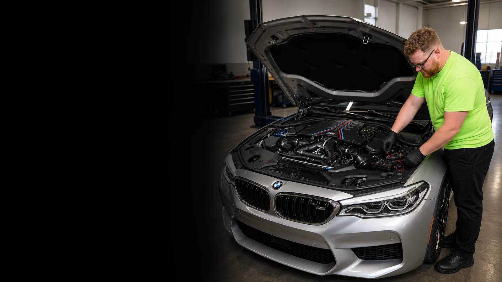 Garrett’s Garage mechanic checking the engine-bay fuse box of a silver BMW